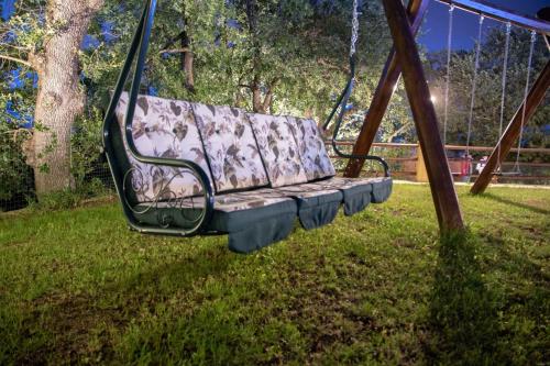 a swing in a park in the grass at BorgoPratole CountryHouse in Cingoli