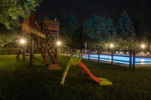 a playground in a park at night with lights at BorgoPratole CountryHouse in Cingoli
