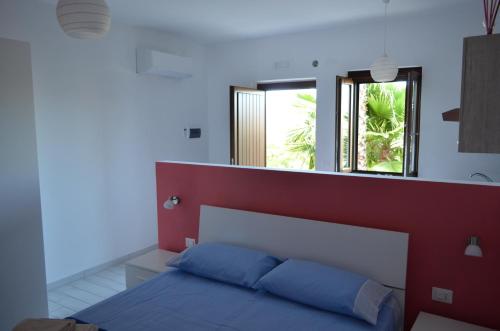 a bedroom with a bed and two windows at Albizia, casevacanza in Agropoli