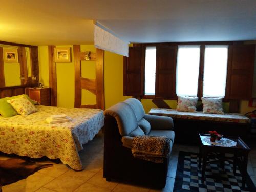 a bedroom with a bed and a couch at Apartamentos La Condesa in Valmeo