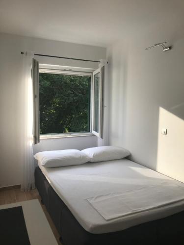 Cama en habitación con ventana en Apartman studio Ganga en Omiš