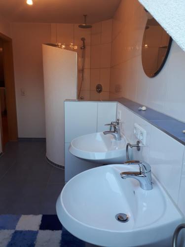 a bathroom with two sinks and a mirror at Ferienwohnung Lochenblick in Balingen