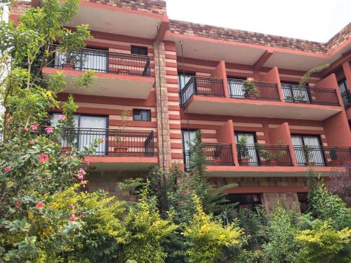 an apartment building with balconies and trees at Harbe Hotel in Lalībela