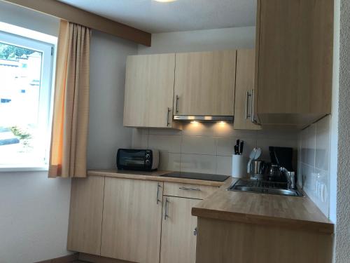a kitchen with wooden cabinets and a sink and a window at Apart Luneta in Ladis