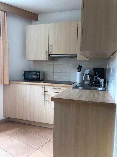 a kitchen with wooden cabinets and a sink at Apart Luneta in Ladis