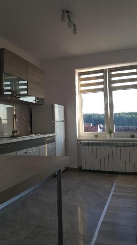 a kitchen with two windows and a table in it at Apartament ULA in Mikołajki