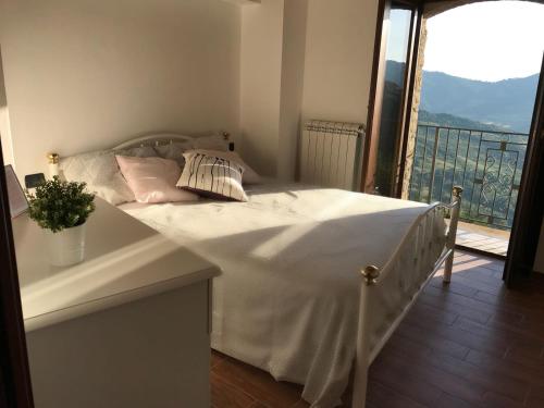 a white bed in a room with a balcony at La Pietra Gialla in Pietrapertosa