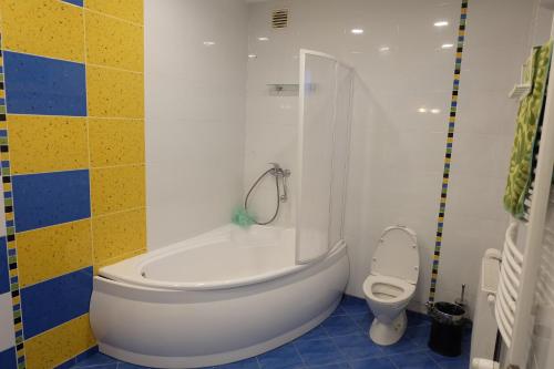 a bathroom with a tub and a toilet at A&L private rooms in Kaunas in Kaunas