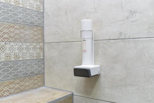 a soap dispenser on a wall in a bathroom at Motel Grand in Velika Kladuša