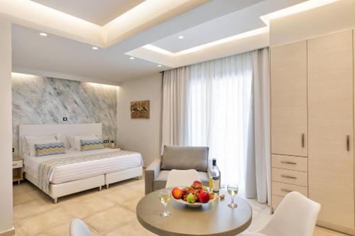 a bedroom with a bed and a table with a bowl of fruit at Belvedere Luxury Apartments & Spa in Plakias
