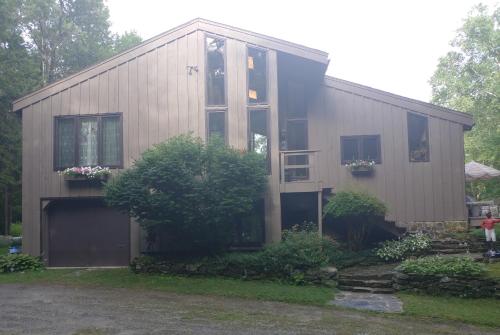 a house with a large window on the side of it at Cricket Hill Lodging in Killington