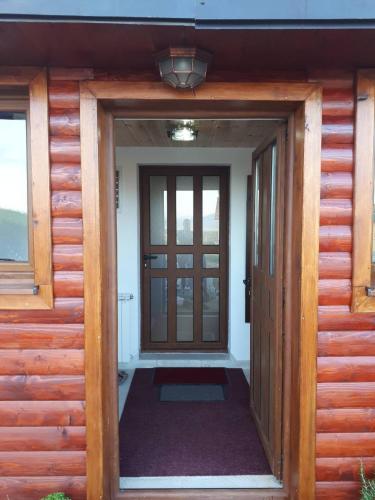 an open door of a wooden house with a porch at House SUN Z&B in Žabljak