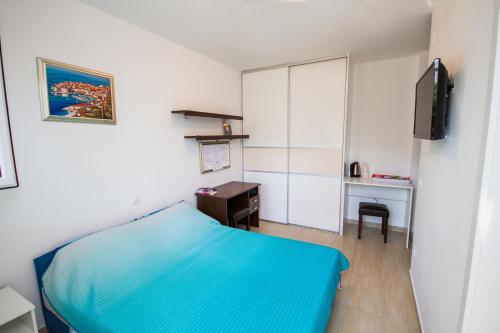 a bedroom with a blue bed and a desk at Apartment Felix in Dubrovnik