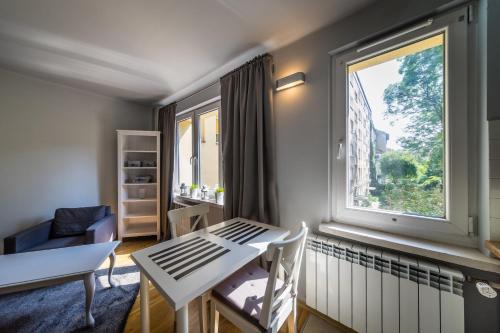 een kamer met een tafel en stoelen en een groot raam bij Krakowska Szuflada in Krakau