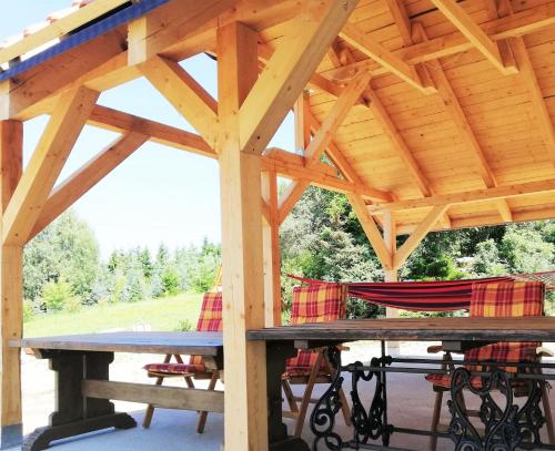 um pavilhão de madeira com uma mesa de piquenique e cadeiras em Linowo 10 Country House em Linowo