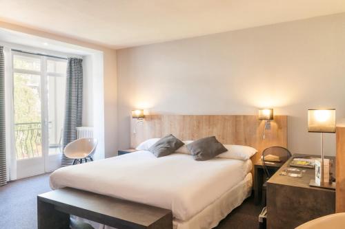 アルジュレス・ガゾストにあるLogis Hôtel Le Miramontの大きなベッドと窓が備わるホテルルームです。