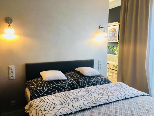 una camera con un letto con due cuscini sopra di Piper Zajezdnia White a Poznań