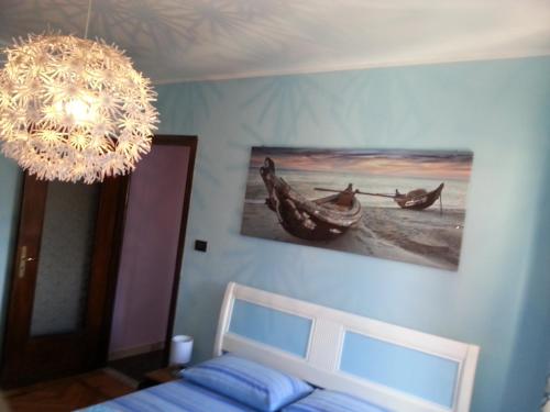 a bedroom with a chandelier and a bed and a picture at Arc en ciel in Aosta