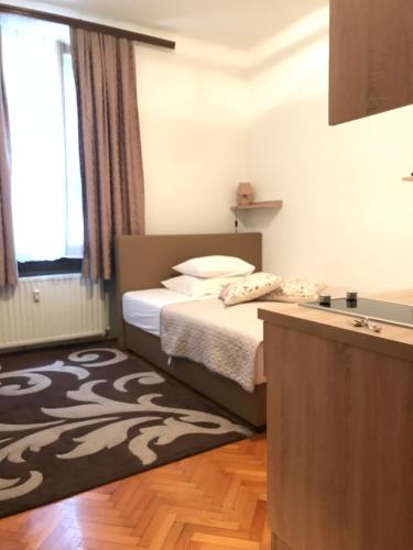 a small bedroom with a bed and a rug at Studio apartment Sisters3 in Ljubljana