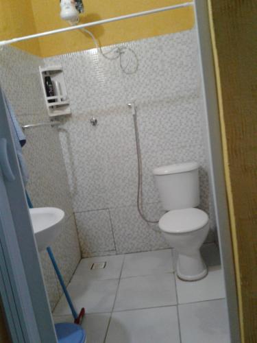 a small bathroom with a toilet and a sink at Pousada da Didi in Belém