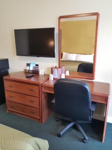 a hotel room with a desk with a mirror and a bed at Echo Lodge in West Sacramento