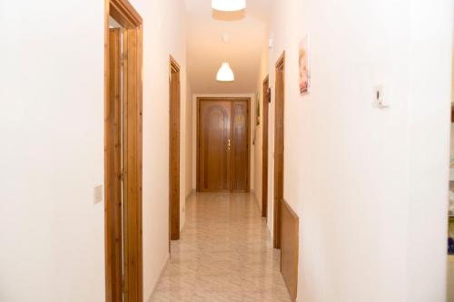 a hallway with white walls and a hallway with wooden doors at BnB acasaconme in Lucito