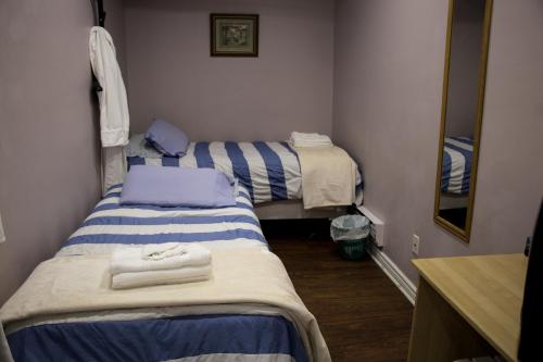 a small room with two beds and a mirror at Saint Lawrence Residences and Suites in Toronto