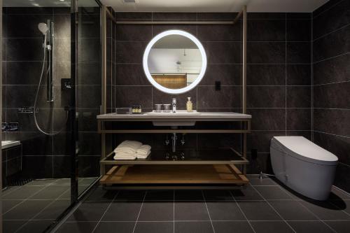 a bathroom with a sink and a mirror and a toilet at HOTEL THE FLAG Shinsaibashi in Osaka