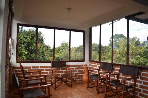 a room with a row of chairs and windows at Hostal Pachamama in San Agustín