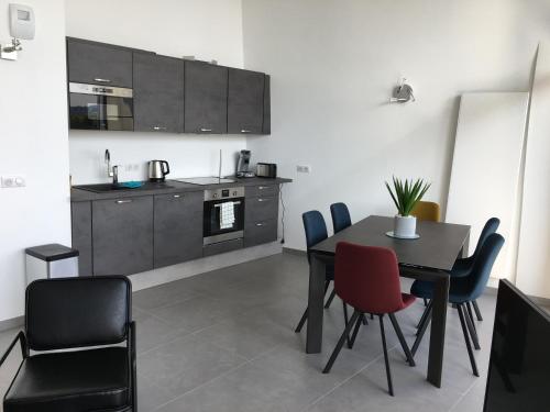 une cuisine et une salle à manger avec une table et des chaises dans l'établissement le Perchoir du Lac, à Annecy