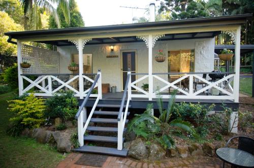 a small white house with a staircase leading to it at Kidd Street Cottages in Mount Tamborine