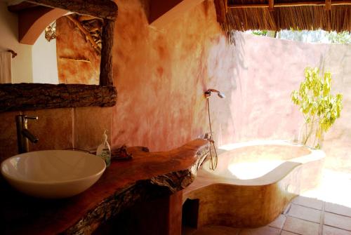 a bathroom with a sink and a bath tub at Karamba Eco Boutique Hotel in Kizimkazi