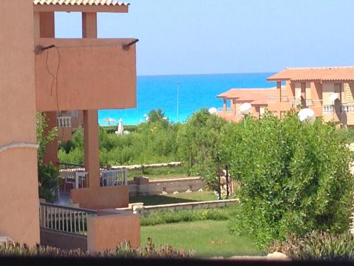a view of a house with the ocean in the background at Fantastic Chalet ,North coast in Dawwār ‘Abd Allāh