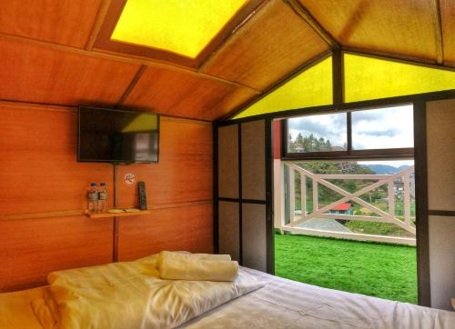a bedroom with a bed and a large window at Kea Garden Mini Chalet in Cameron Highlands