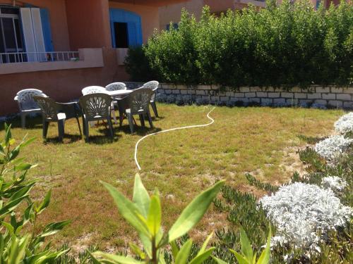 a yard with chairs and a table with a hose at Fantastic Chalet ,North coast in Dawwār ‘Abd Allāh