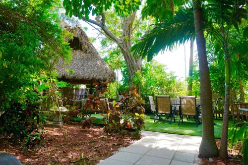 a patio with a table and chairs in a garden at Riverside by the Beach Apartments in Pompano Beach