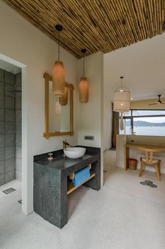 a bathroom with a sink and a mirror at Que Toi Village Resort Phu Yen in Song Cau