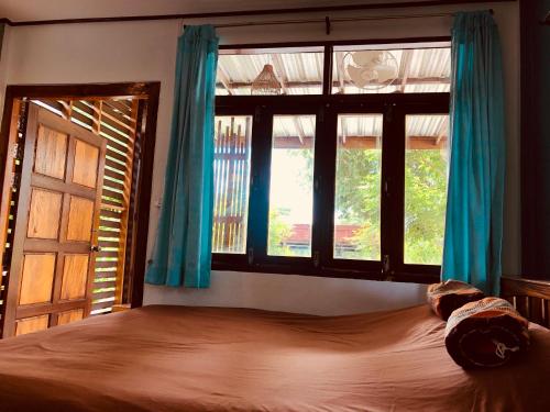 a bedroom with a large bed and a window at JJ at Chiangkhan in Chiang Khan