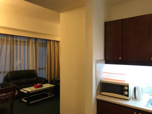 a living room with a couch and a microwave at Apartment Times Square With Infinity Pool in Kuala Lumpur