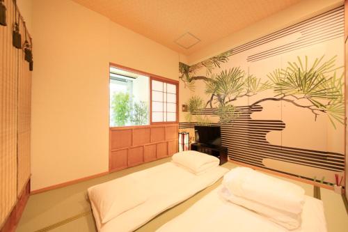 東京にある上野ステーションホステル オリエンタル1（男性用）のベッド2台と窓が備わる客室です。