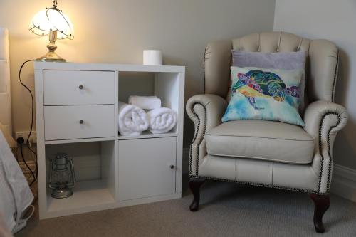 a chair with a pillow next to a white cabinet at Regent Residential Villa in Whangarei