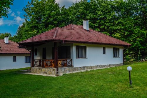 a small white house with a red roof at Gabarite Holiday Village in Apriltsi