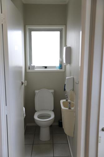 a small bathroom with a toilet and a sink at Regent Residential Villa in Whangarei