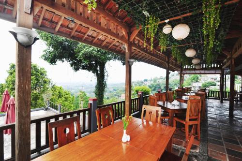a restaurant with a wooden table and chairs on a balcony at Dago Highland Resort in Bandung