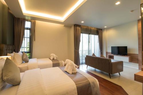 a hotel room with two beds and a television at Green Ville Laguna Hotel in Sung Noen