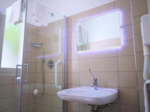 a bathroom with a sink and a shower at Hotel Perla Gaia in San Vito lo Capo