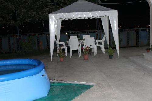 a gazebo with a table and chairs and a pool at Villa Near The Batumi in Batumi