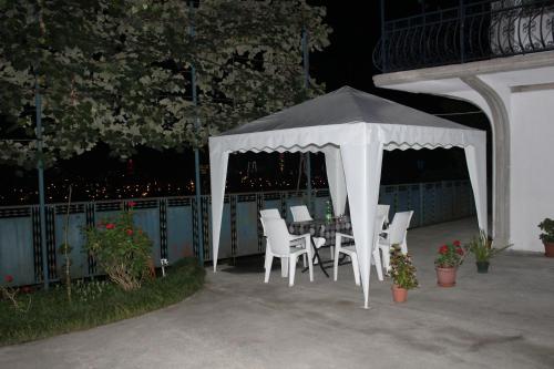 a white gazebo with chairs and a table at Villa Near The Batumi in Batumi