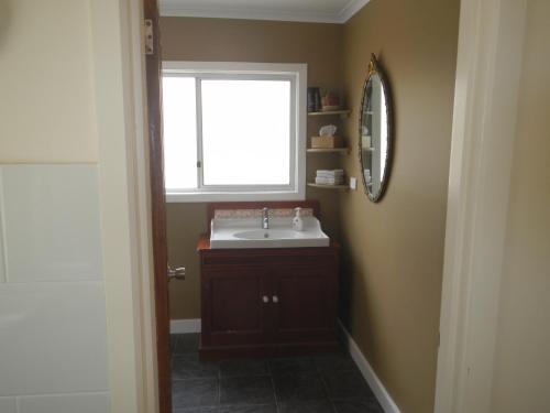 a bathroom with a sink and a window at Yarram Cottage: Art and Accommodation in Yarram