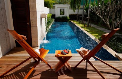 two chairs and a table next to a swimming pool at Villa 3 Bedrooms with private pool at Oxygen Bangtao in Bang Tao Beach